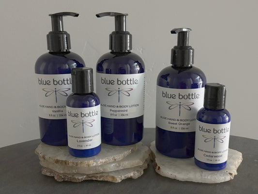 Collection of Blue Bottle Body Care Aloe Hand and Body Lotion products on a stone surface with a neutral background